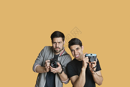 在彩色背景上用数码相机拍摄年轻男性朋友的肖像图片
