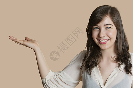 一个快乐的年轻女人的肖像 空手过彩色背景图片
