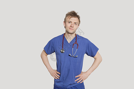 男性外科医生的肖像 用手站在灰色背景上的臀部上图片
