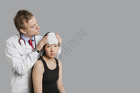 医生调整病人头部的绷带图片