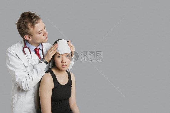 医生调整病人头部的绷带图片