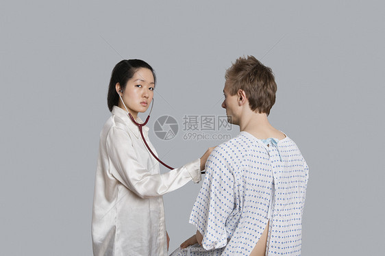 一名年轻女医生检查男性病人的肖像图片
