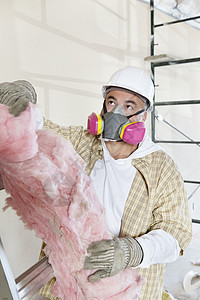 男子承包商在建筑工地持有海绵时戴着灰罩 身着灰色面具图片