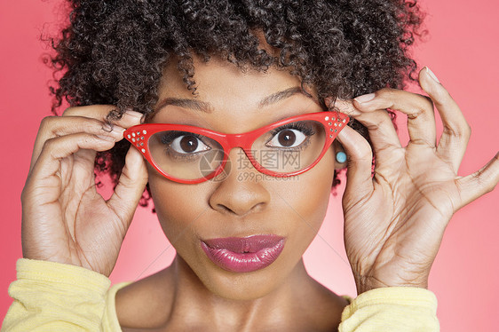 一名非洲裔美国妇女身着彩色背景的眼镜反覆式镜片的肖像图片