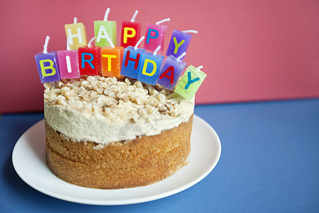 以彩色背景在托尔特蛋糕上特写生日蜡烛图片