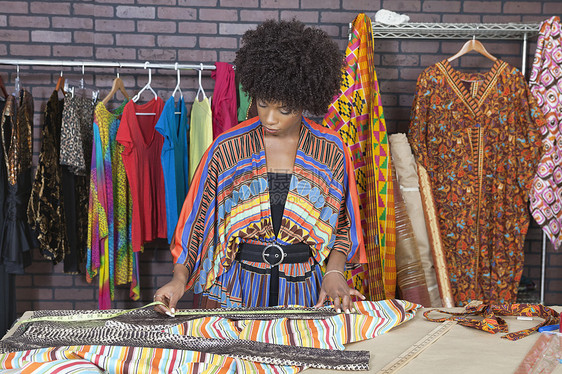 非裔美国女设计师在设计工作室测量布料图片