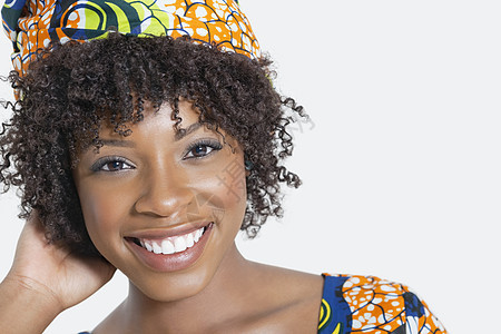 一位非洲裔美国女性在灰色背景下微笑的近距离肖像图片