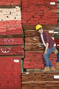 亚洲女性工业女工站在堆叠的木木板上 手持平板电脑图片