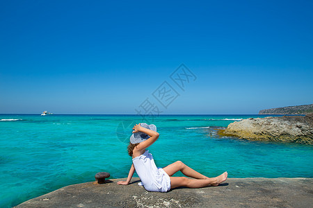 女孩在Formentera绿绿石地中海的海滩观望海洋帽子游客女士海岸线支撑裙子旅行闲暇孩子们图片