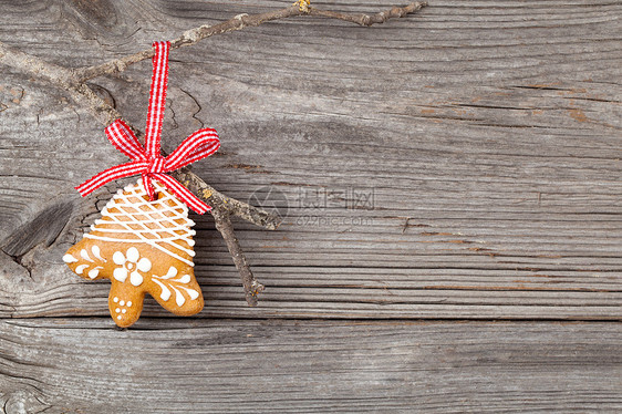 姜饼饼干挂在木头背景上 圣诞装饰礼物饼干食物冰镇雪花装饰甜点水平棕色丝带图片