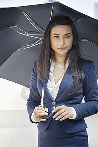 一名手持伞子的年轻印度女商务人士的肖像图片