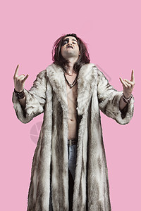 穿着毛皮大衣的年轻男子肖像 在粉红背景上画着摇滚音乐标志图片