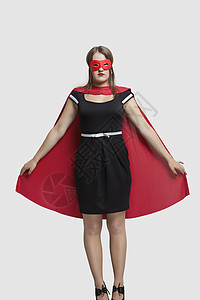 年轻女性站在超级英雄服装中 身穿灰色背景的女青年图片