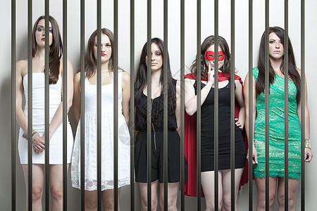穿着超级英雄装扮的女人 和女朋友站在监狱牢狱后面五个人成人囚犯警察拘留所惩罚女性铁窗犯罪禁闭室图片