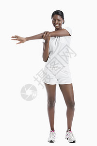一位非裔美国年轻女子的肖像 将手臂伸展在白色背景上微笑闲暇影棚成年拉伸运动身体素质女性运动服成人图片
