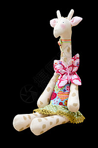 手使柔软的玩具长颈鹿在坐着的衣服上被孤立图片