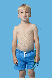 一个快乐的年轻男孩身穿蓝底泳裤 穿着蓝底泳裤的肖像图片