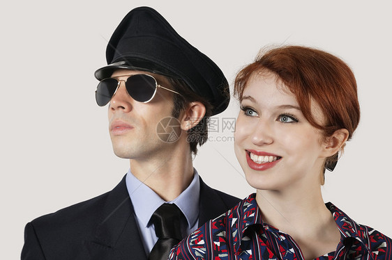 快乐的女乘务员和灰色背景驾驶员的肖像两个人男性头肩空姐影棚微笑成人戏服视图男子图片