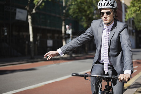 青年商务人士在骑自行车时佩戴手印图片