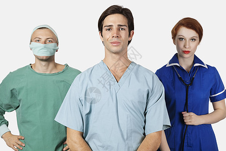 在灰色背景下对3名有自信的执业医师进行纵向攻击制服手术帽保健成人外科男子医生彩色磨砂膏影棚图片