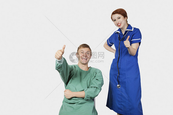 年轻男性病人与女护士在灰色背景下用拇指抚摸女性护士的肖像图片