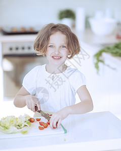 年轻女孩在厨房切西红柿做沙拉和煮番茄情感青年休闲服午餐食物漏洞短发青春期幸福孩子图片