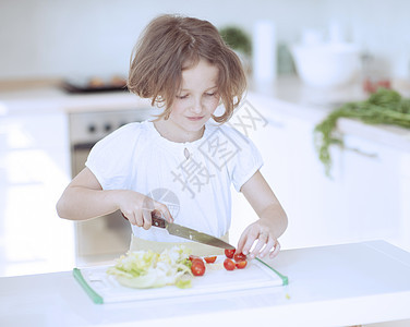 年轻女孩在厨房切西红柿做沙拉和煮番茄情感孩子短发食物青春期幸福午餐想像力青年烹饪图片