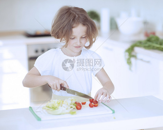 年轻女孩在厨房切西红柿做沙拉和煮番茄情感孩子短发食物青春期幸福午餐想像力青年烹饪图片