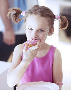 年轻女孩在厨房吃蛋糕女性家庭食物尾巴表情焙烤房间幸福粉色女儿图片