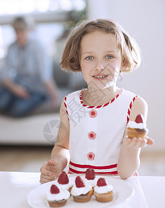 持有杯蛋糕的年轻女孩衣服食物焙烤房间幸福家庭母亲糖果盘子厨房图片