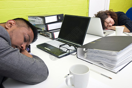 同事在各自的办公桌睡着男性办公室午睡人士男人女士电脑衣服石灰绿技术图片