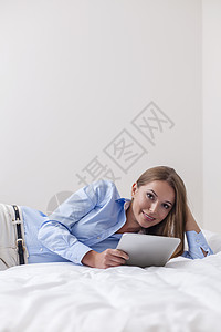 在床上使用平板电脑的漂亮女美女房间阅读硬件通讯娱乐爱好闲暇卧室上网双腿图片