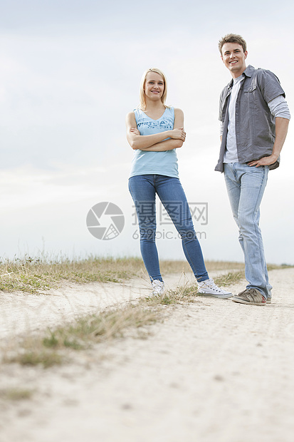 站在田野足迹上的年轻夫妇全长肖像图片