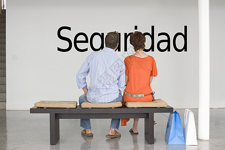 阅读西班牙文“seguuridad”(安全)的一对夫妇观点图片