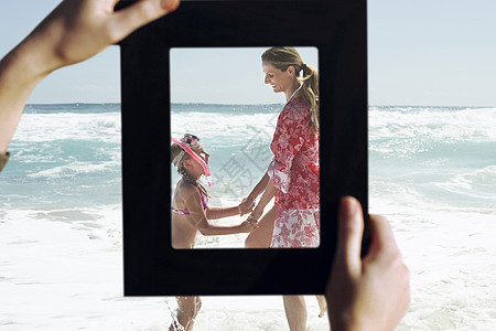 在海滩上玩水的母和女用手搭配母亲和女儿图片