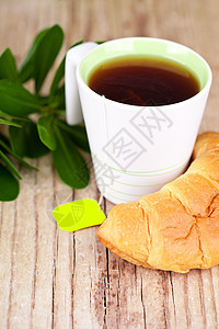 茶杯和新鲜的羊角面包糕点茶点茶包食物杯子小吃甜点木头雏菊乡村图片