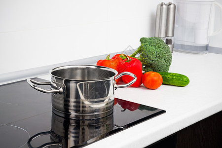 现代厨房加上岗炉灶的锅和蔬菜橱柜烹饪胡椒植物玻璃公寓拨号活力滚刀陶瓷图片