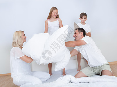 拥有共同卧床的枕头斗争的家庭兄弟姐妹男孩们卧室父母男人女性童年姐姐闲暇喜悦图片