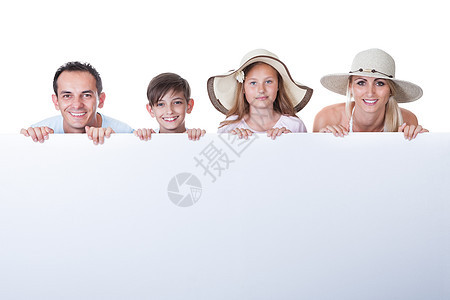 白板后面的家庭肖像成人广告标语微笑喜悦父母工作室女性亲热童年图片