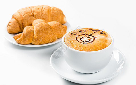 大杯咖啡和盘子上的羊角面包香气泡沫饮料液体报纸蛋糕小吃橙子杯子食物图片