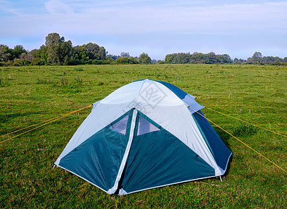 在河边草原上的私人露营帐篷远足庇护所旅游游客草地休息绿色钓鱼白色图片