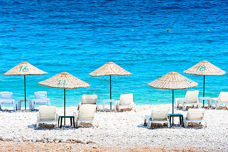 海边的空甲板椅子 和挂着的雨伞图片