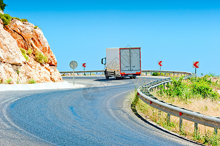 在阳光明媚的一天驾驶卡车在山路上行驶图片