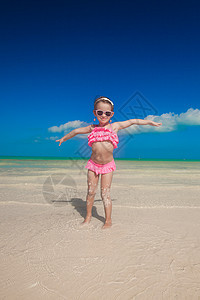 小女孩在白沙滩上张开双臂婴儿异国微笑旅行海景旅游女儿情调支撑海滩图片