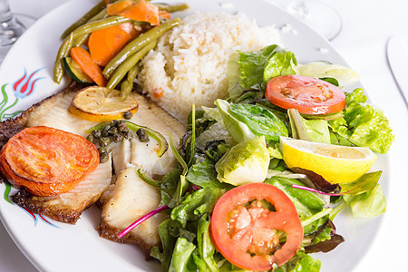 用柠檬和番茄煮熟的蒂拉皮亚盘子用餐香菜午餐海鲜食谱美食烹饪蔬菜尾巴图片