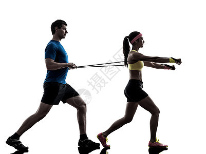 与男教练一起行使健身抗力橡皮带的妇女健美有氧运动辅导运动员阴影训练男人松紧带有氧夫妻图片