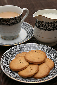 装满了饼干的盘子加牛奶壶和一杯茶牛奶甜点奢华巧克力陶瓷蛋糕食物芳香餐厅飞碟图片
