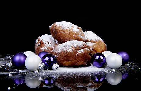 荷兰甜甜甜圈又称奥利博伦 传统新叶棕色葡萄干白色育肥黑色粉状紫色国家食物背景图片