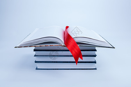 在一堆书上打开一本书红色教育日记数字丝带白色阅读页数机构图书馆图片