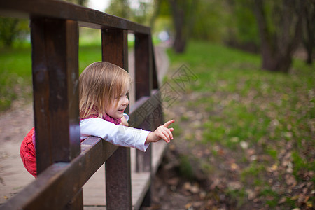 小女孩在户外散步 玩乐和笑乐趣孩子快乐幸福童年阳光女孩木头蓝色森林图片